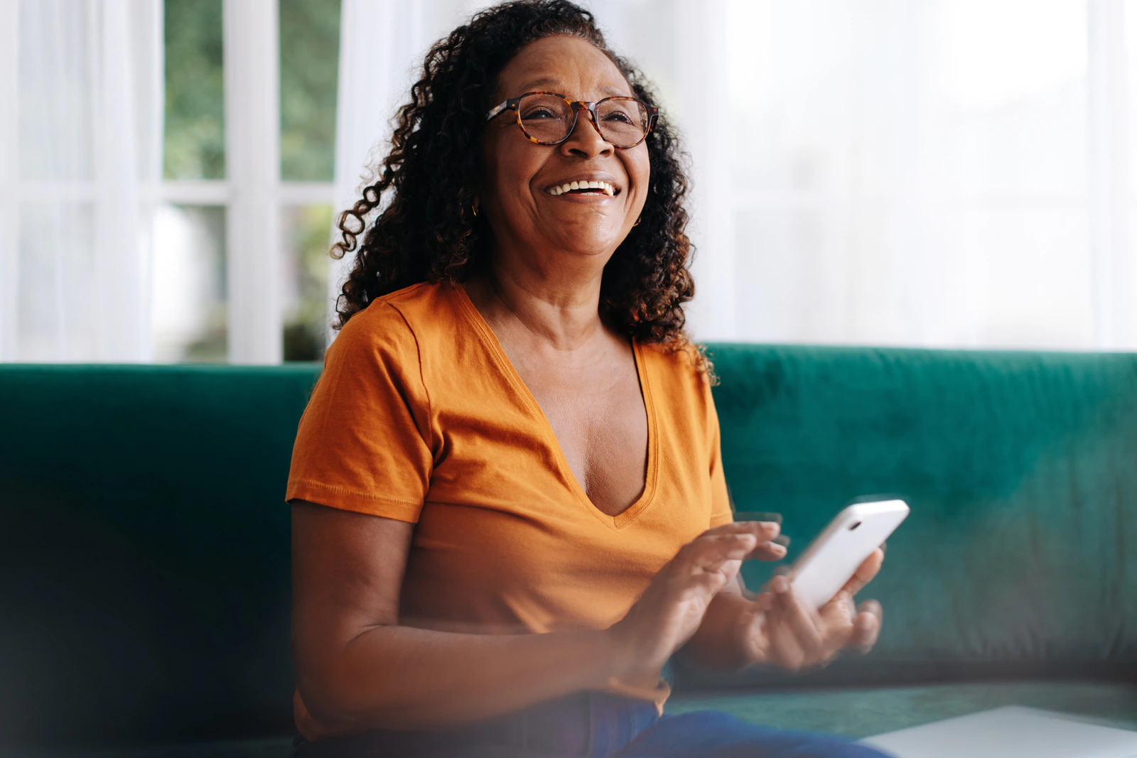 Une femme souriante utilisant son téléphone.